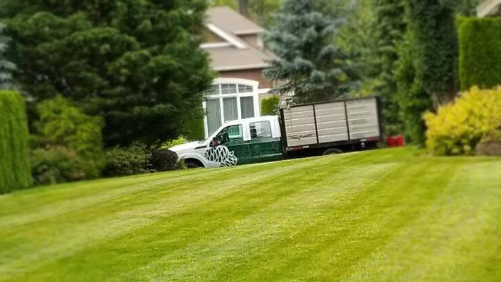 Lush green lawn, service truck.